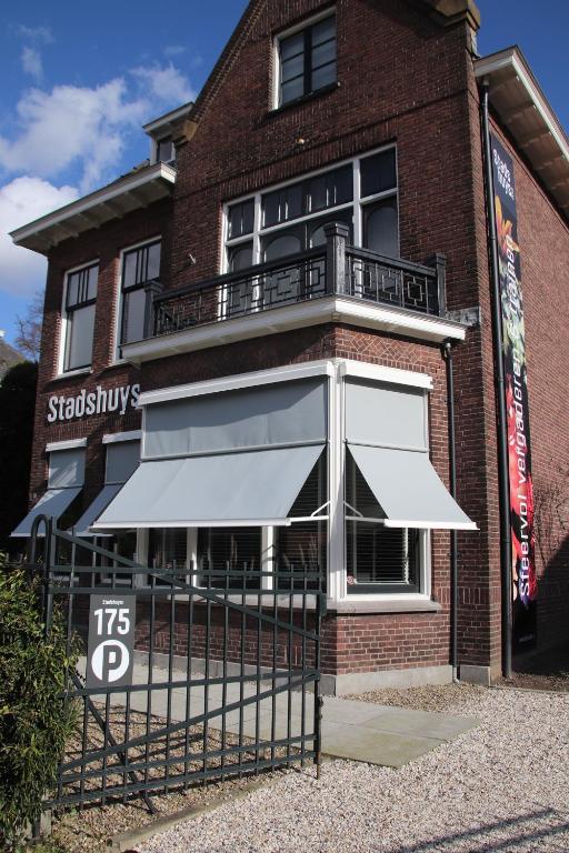 un edificio de ladrillo con un paraguas delante de él en Studio Stadshuys053, en Enschede