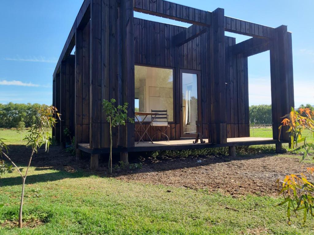 uma pequena casa de madeira com uma grande janela em Nenquen Lodge em Santa Cruz