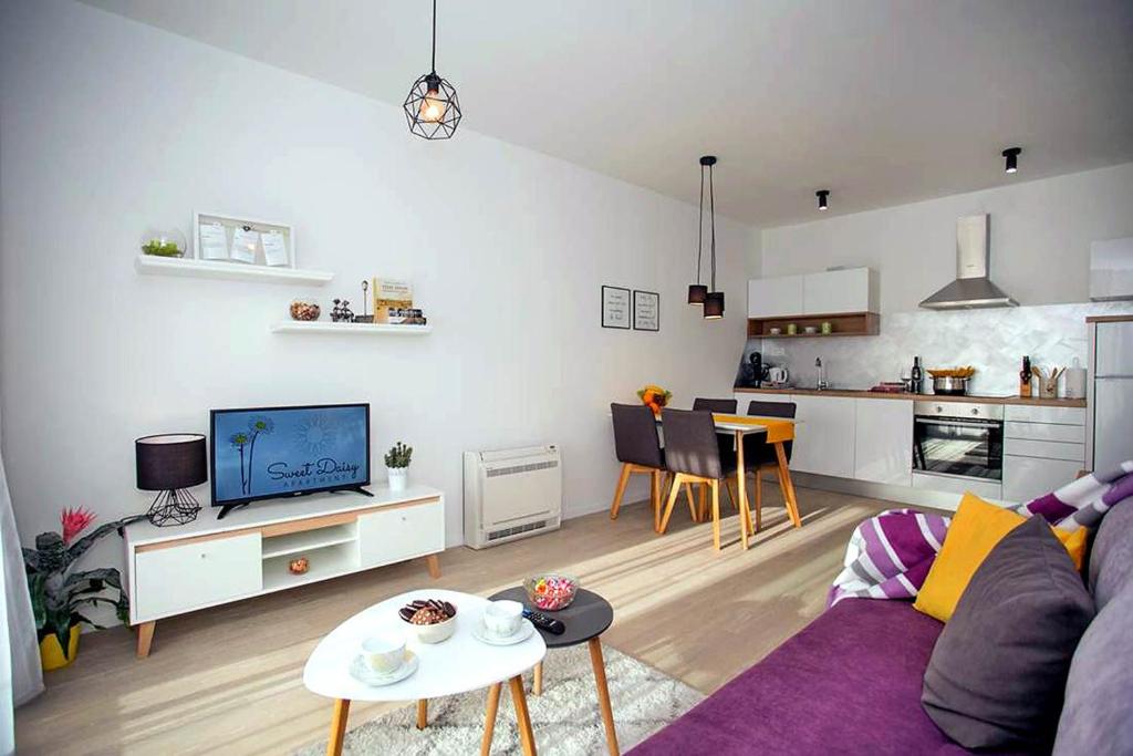 a living room with a purple couch and a kitchen at Apartment Sweet Daisy with parking in Zadar