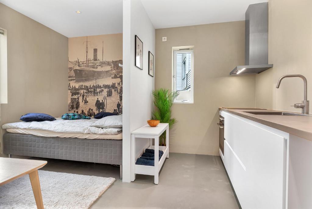 uma cozinha com uma cama no canto de um quarto em Central Studio Apartment Apt 101 em Stavanger