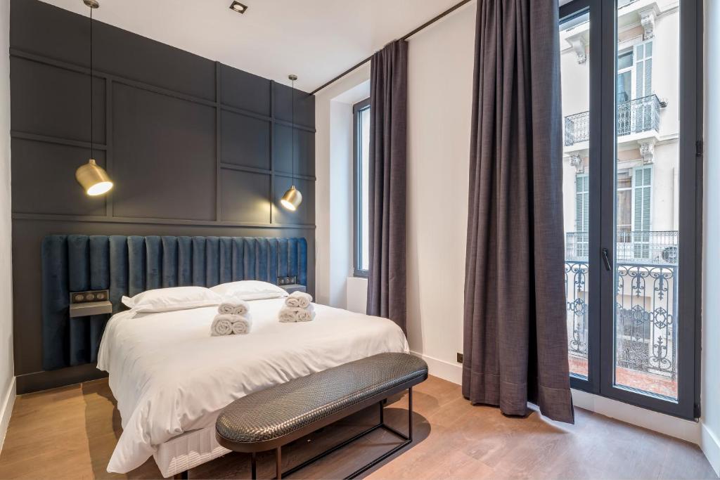 een slaapkamer met een bed en een groot raam bij RESIDENCE MONTEFIORE in Cannes