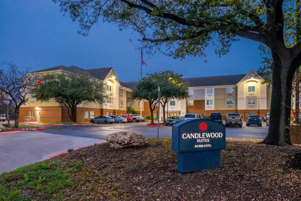 a sign in front of a building with a car dealership at Candlewood Suites Austin-Round Rock, an IHG Hotel in Round Rock