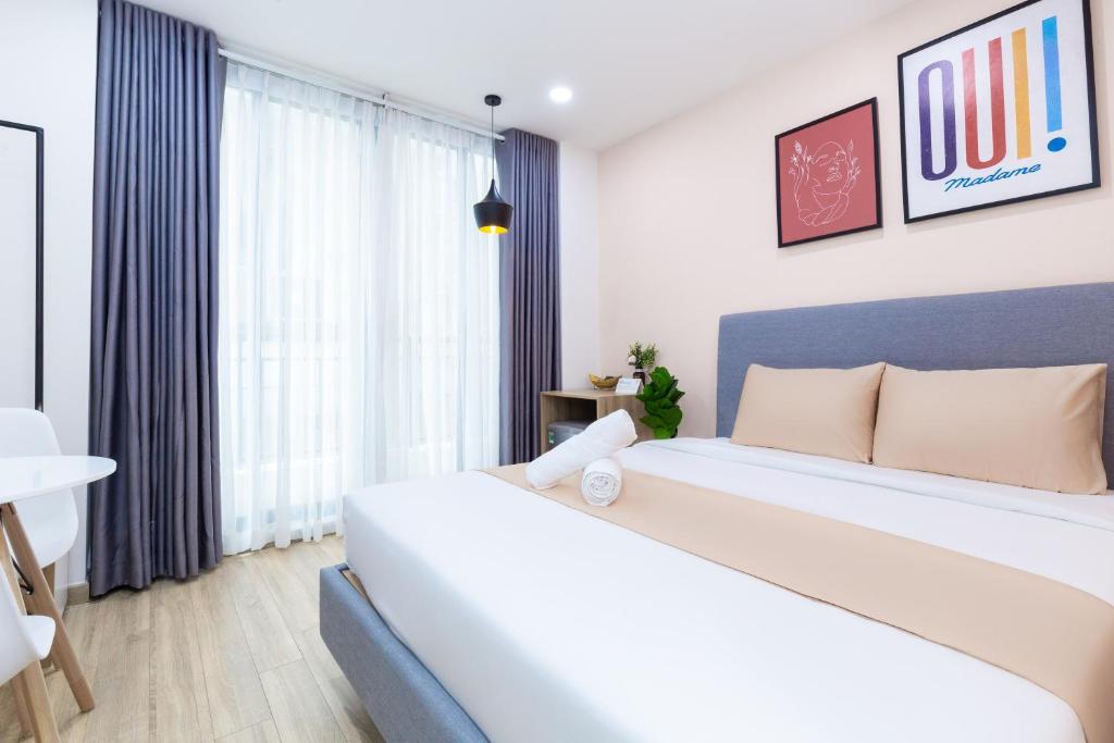 ein Schlafzimmer mit einem großen Bett und einem Fenster in der Unterkunft Cozrum Homes - Charming Corner in Ho-Chi-Minh-Stadt