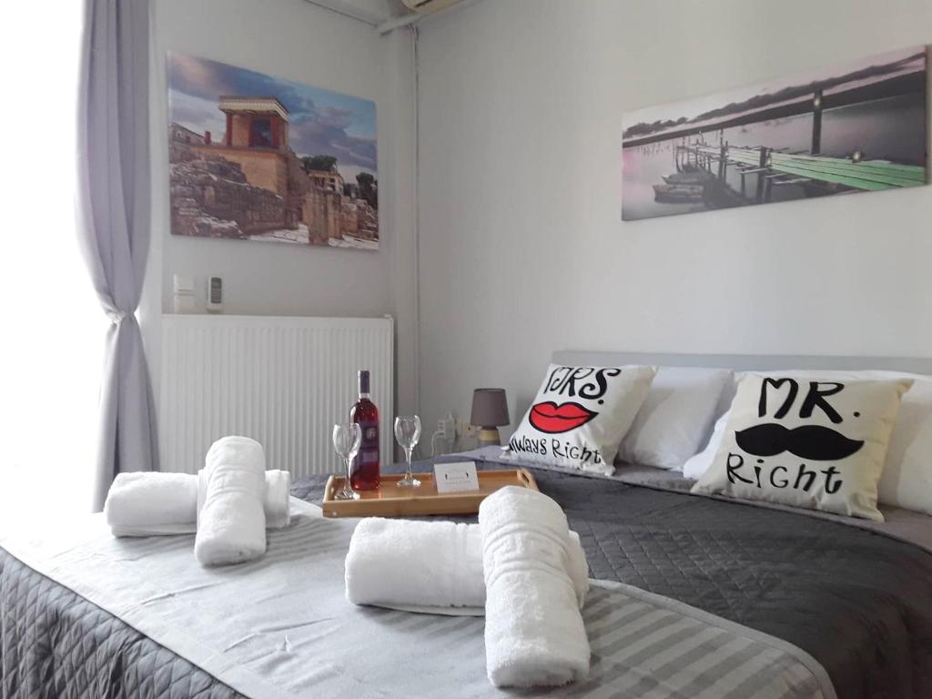 a bedroom with a bed with white pillows and a table at Gerapetros 82 in Ierapetra