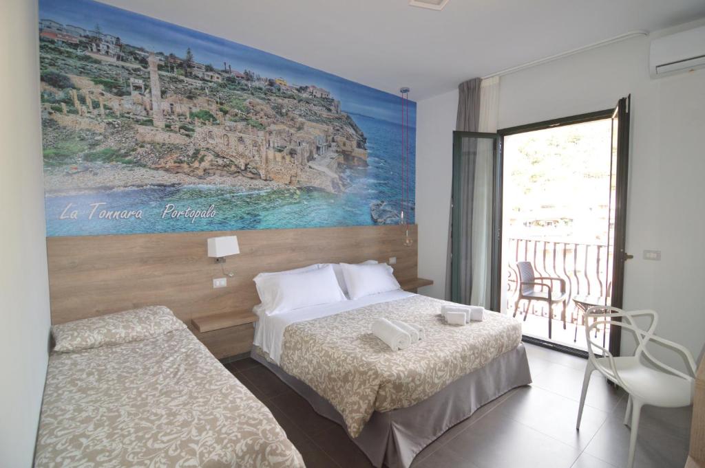 una camera d'albergo con due letti e un dipinto sul muro di NEW Casa Corvaja a Taormina