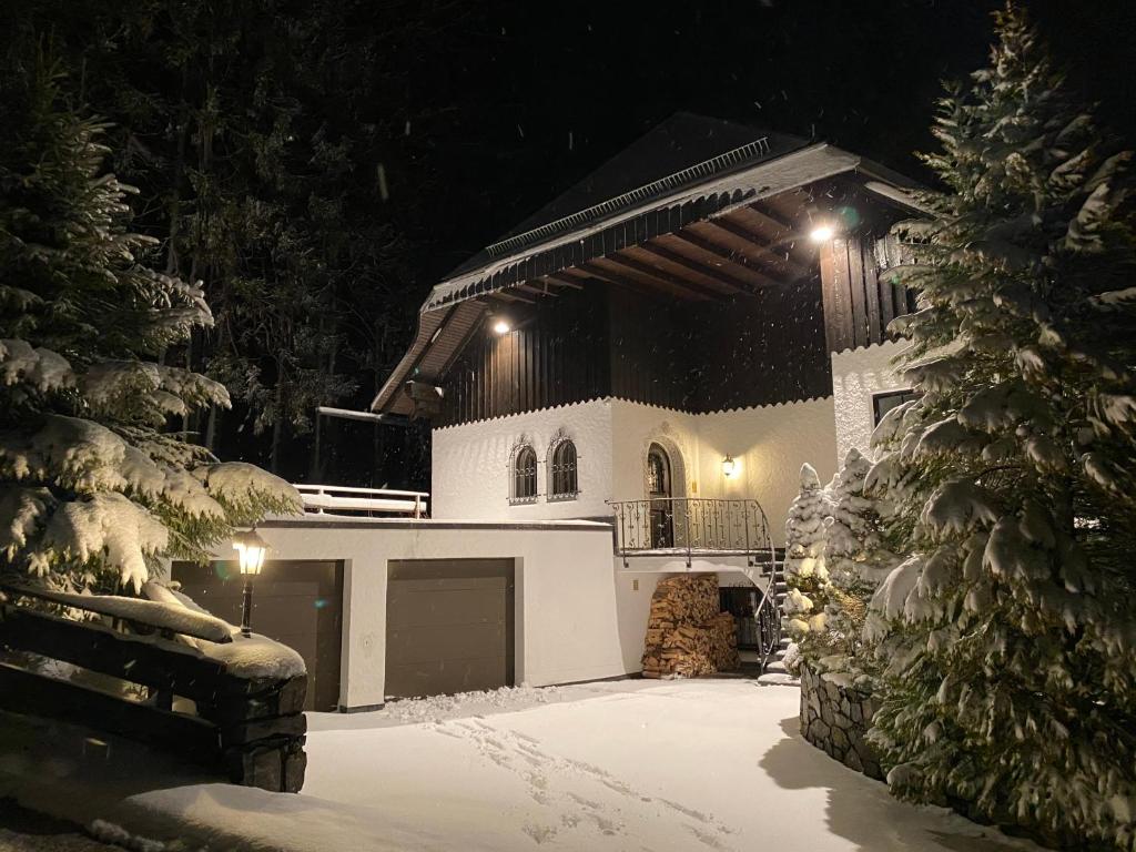 a house with a garage in the snow at night at Schwarzwald-Villa mit Indoor-Pool in Feldberg