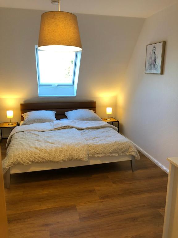 a bedroom with a bed with a window above it at Apartment Hoyerhagen in Hoyerhagen