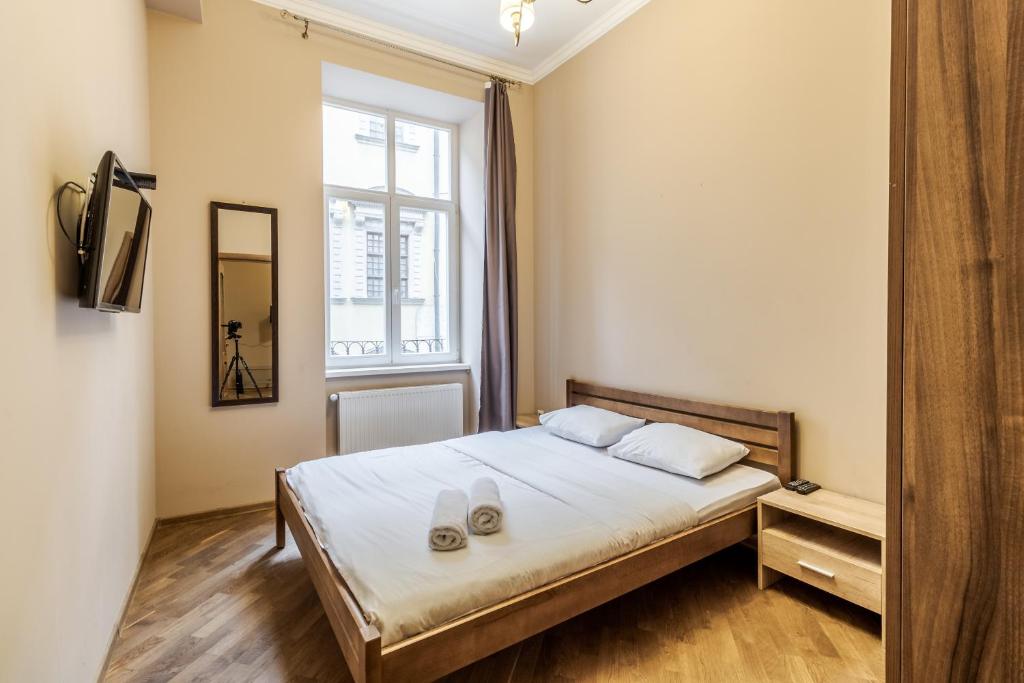 1 dormitorio con cama y ventana en Apartment on Stavropihiiska Street 3, en Leópolis