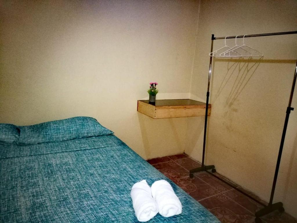 Un dormitorio con una cama con toallas blancas. en Apartamentos Morpho CR 2 en Quepos