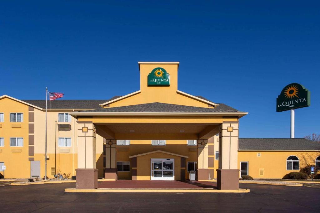 a large yellow building with a sign on it at La Quinta Inn by Wyndham Peru Starved Rock State Park in Peru