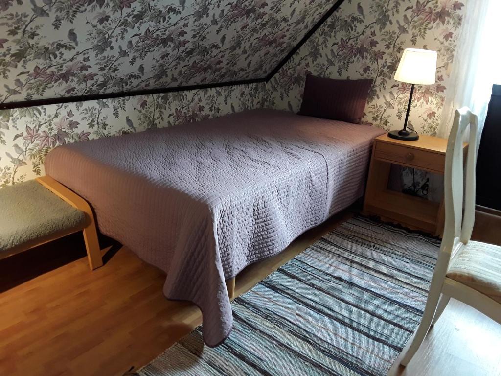 um quarto com uma cama, um candeeiro e uma cadeira em Naturnära enkel rum B&B i Uppsala Ramstalund em Uppsala