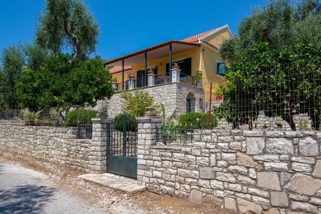 a stone fence in front of a house at Villa RAXI in Plátanos