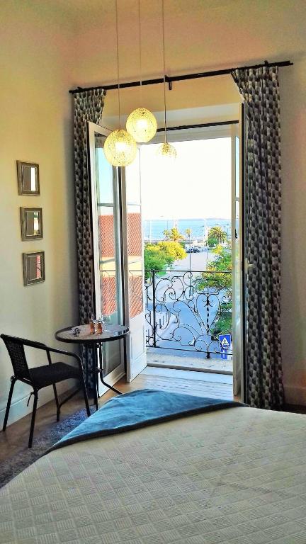 a bedroom with a door open to a patio with a view at Alojamentos Vista Mar-Luisa Todi in Setúbal