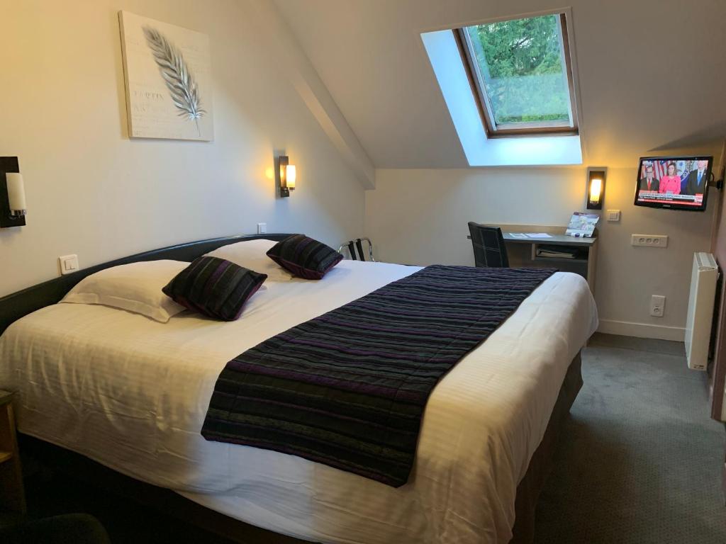 Postel nebo postele na pokoji v ubytování Hôtel Le Bayeux