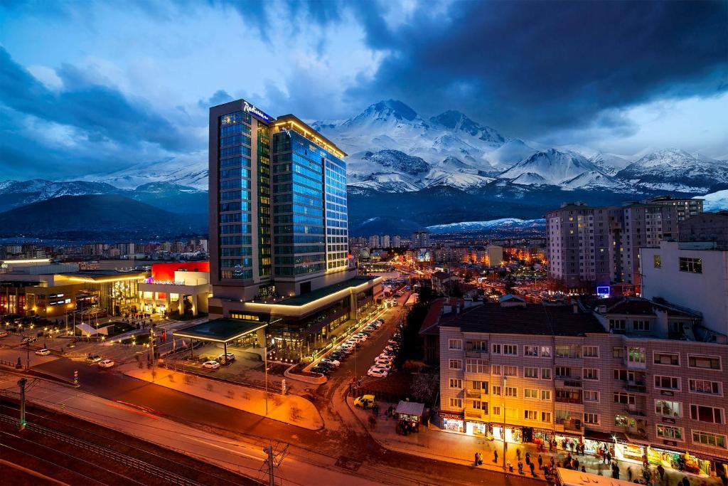 a city with a tall building in front of mountains at Radisson Blu Hotel, Kayseri in Kayseri