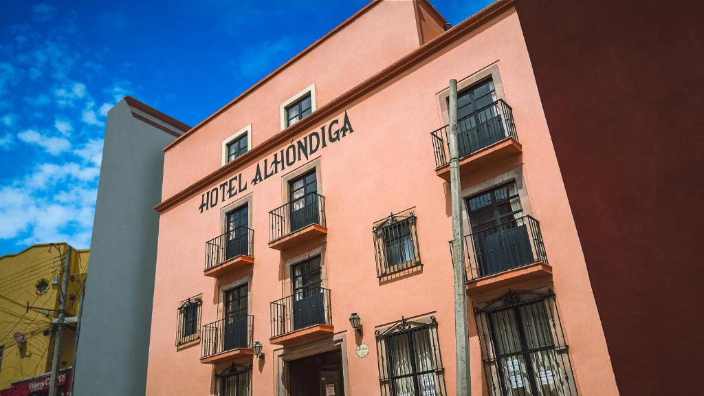 un bâtiment rose avec un panneau sur son côté dans l'établissement Hotel Alhóndiga, à Guanajuato