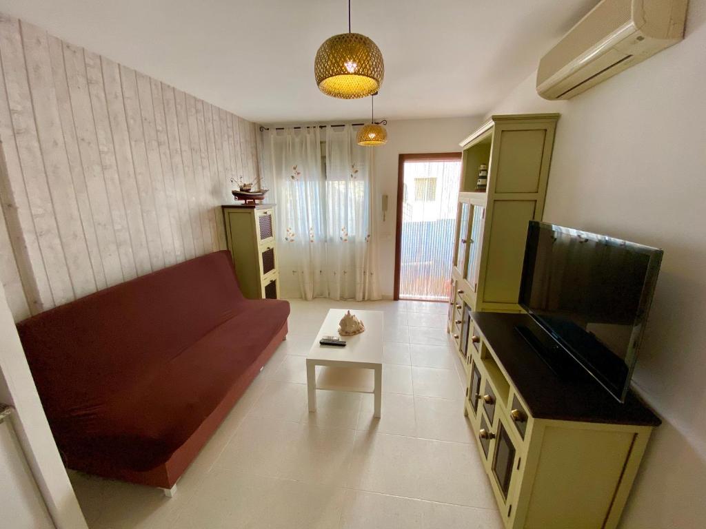 ein Wohnzimmer mit einem Sofa und einem TV in der Unterkunft Apartamento con piscina a 350 metros de la playa in Vinarós