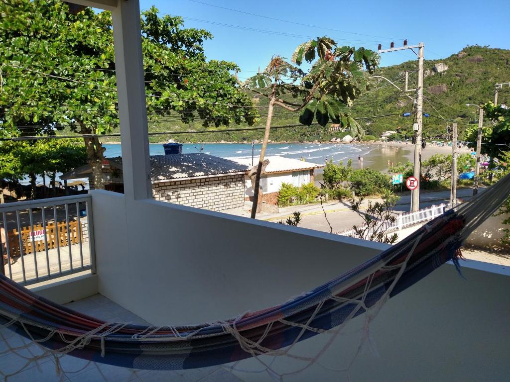 a hammock on a balcony with a view of a street at Casa Beira Mar Mariscal Superior in Bombinhas