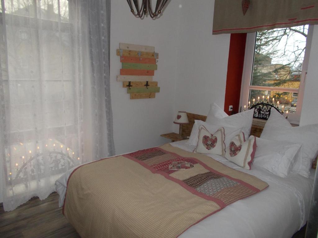 um quarto com uma cama com almofadas brancas e uma janela em Ferienwohnung "Hinter den sieben Bergen" em Schwarzenberg