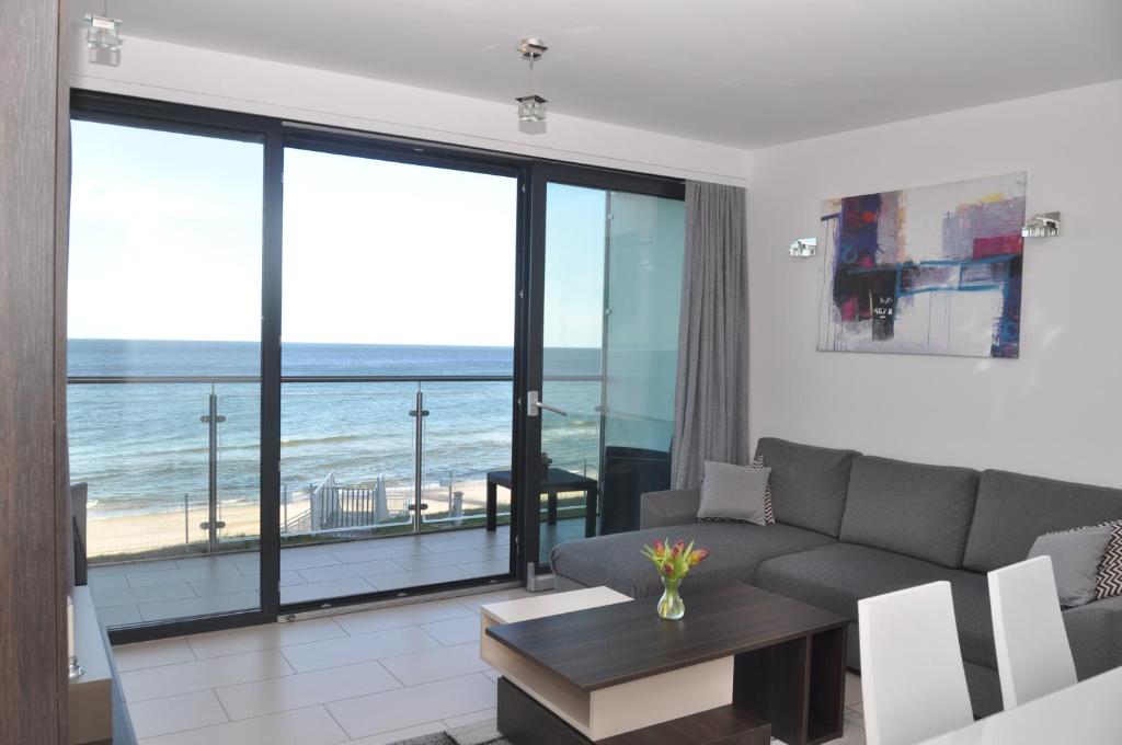 a living room with a couch and a view of the ocean at Ostseeblick Rewal in Rewal
