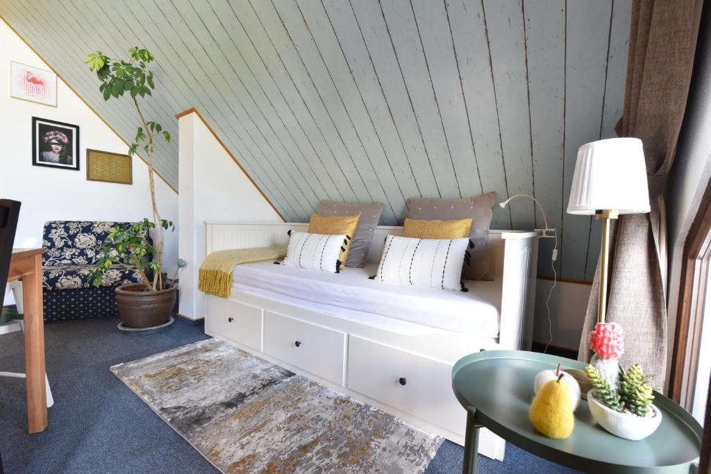 ein Schlafzimmer mit einem weißen Bett mit Kissen darauf in der Unterkunft Fewo Grohlz in Boos