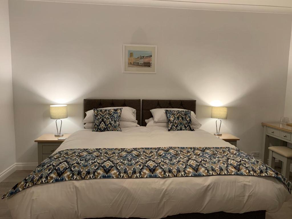 a hotel room with a bed and two lamps at Cotswold Hare in Cirencester