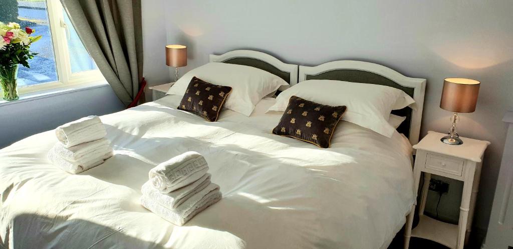 a bedroom with two beds with white sheets and pillows at Maugersbury Park Suite in Stow on the Wold
