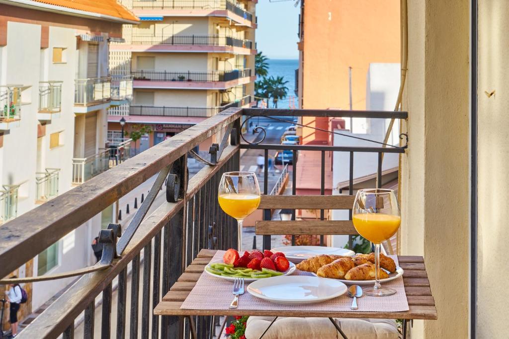 - une table avec deux verres de vin et de nourriture sur un balcon dans l'établissement Picasso 1, à Fuengirola