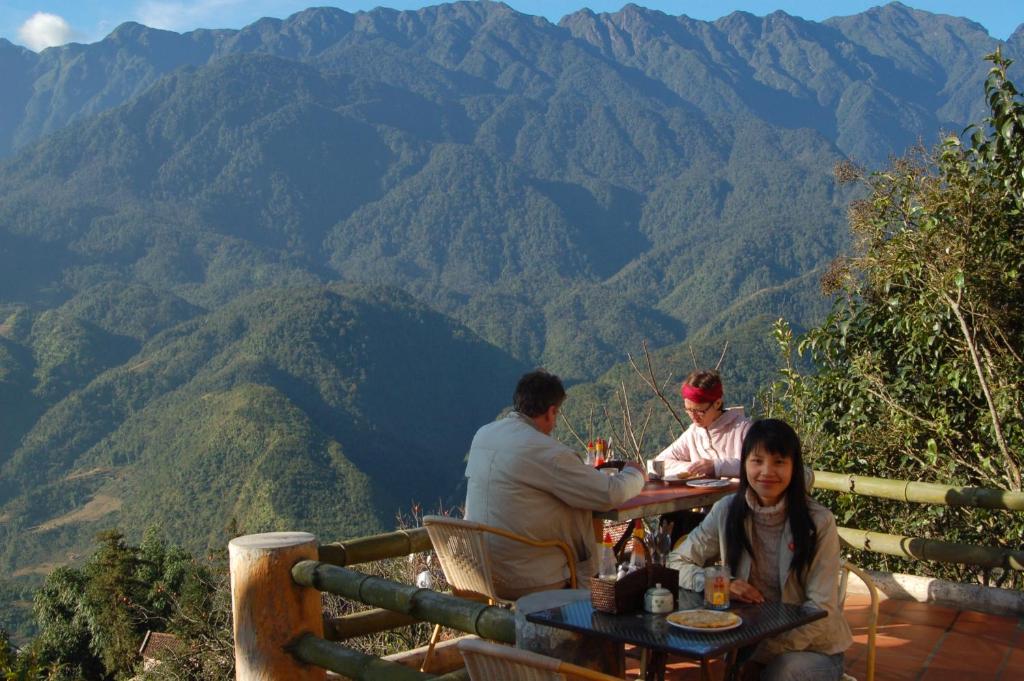 Un groupe de personnes assises à une table dans les montagnes dans l'établissement Cat Cat View Hotel, à Sa Pa