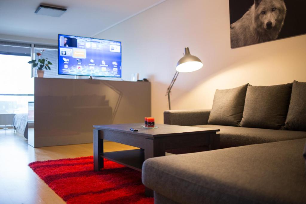 een woonkamer met een bank, een tafel en een tv bij City center apartment Aida in Pärnu