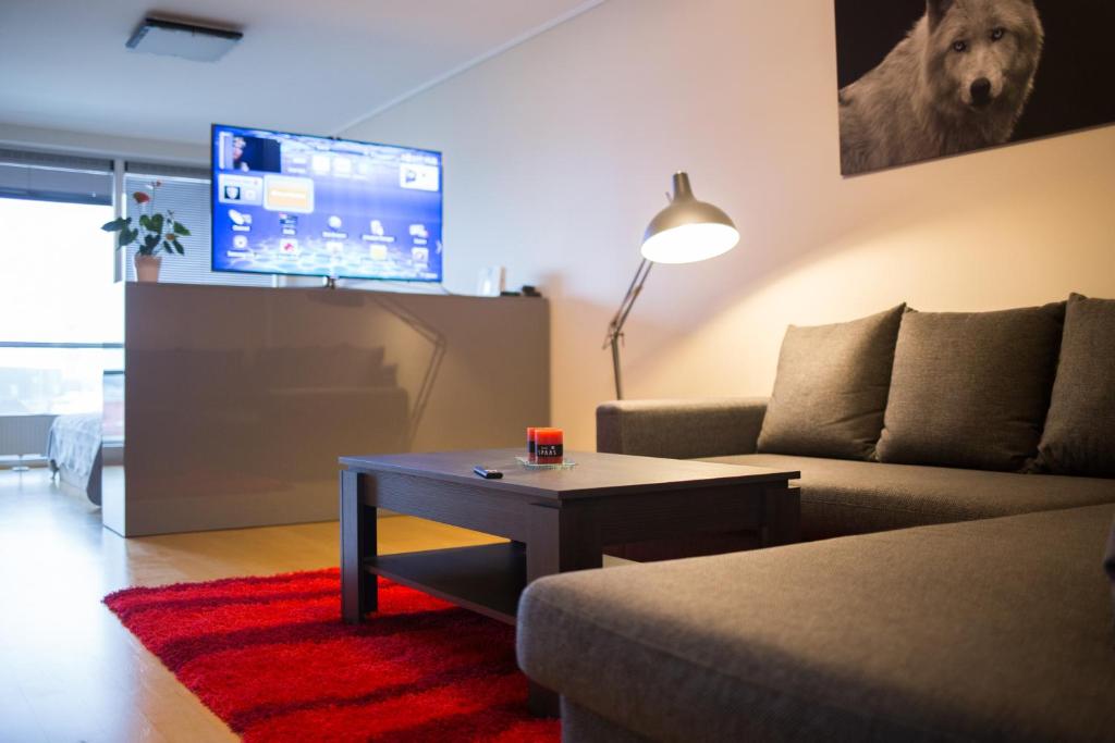 a living room with a couch and a table and a tv at City center apartment Aida in Pärnu