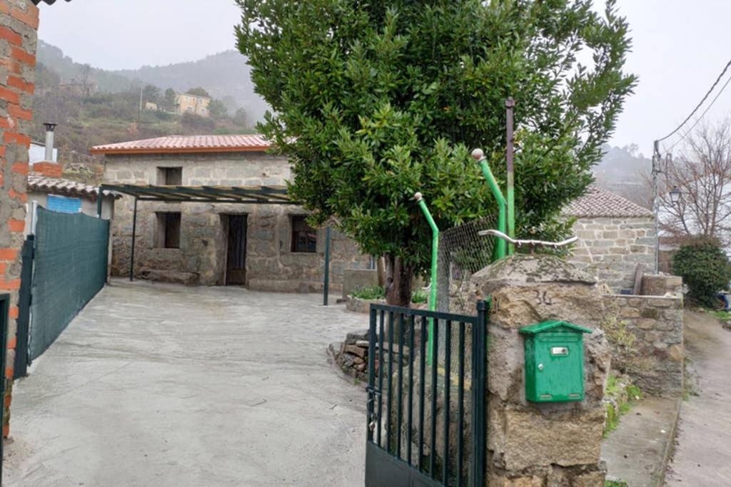 ein Haus mit einem Tor vor einem Gebäude in der Unterkunft Casa en La Rinconada in El Barraco