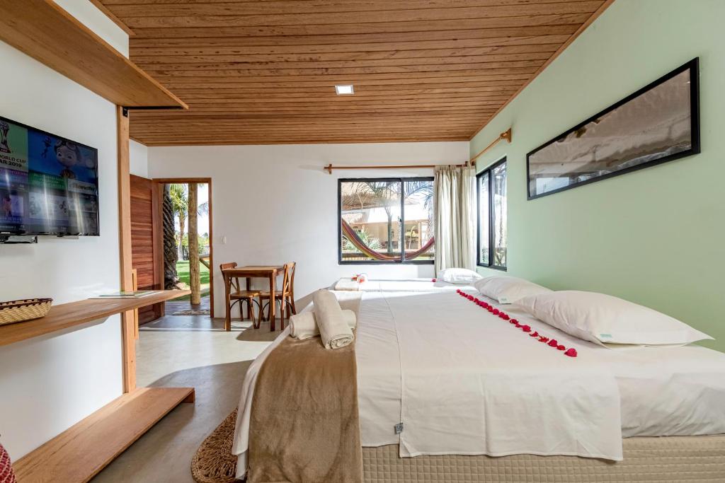 a bedroom with a large bed and a table at Ventura Barra Grande in Barra Grande