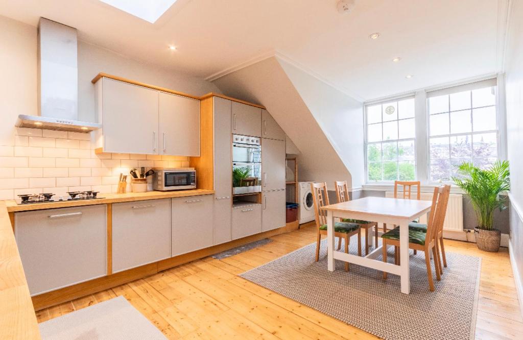 a kitchen and dining room with a table and chairs at New Town Apartment with Castle View in Edinburgh