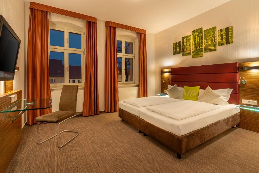 ein Hotelzimmer mit einem Bett und einem TV in der Unterkunft Hotel und Restaurant Zum Deutschen Hause in Lübbenau