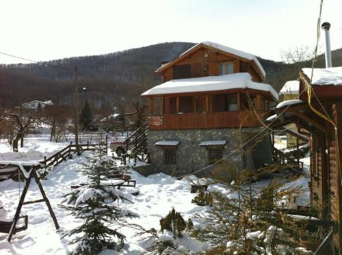 a building with snow on the ground in front of it at Chalet Parea in Metamorfosi
