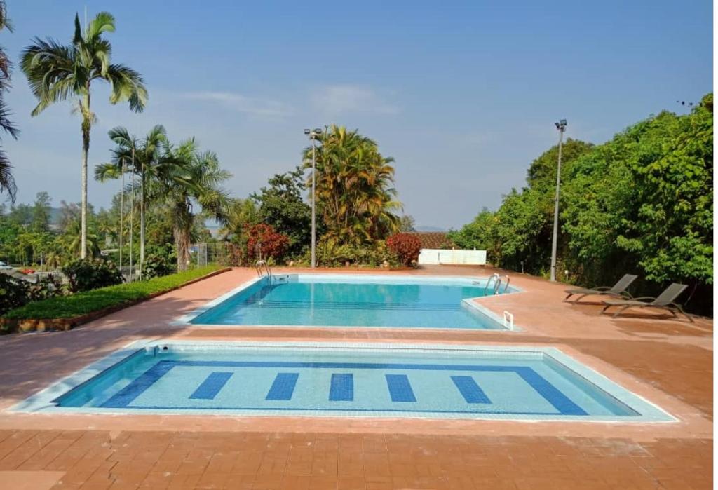 a swimming pool in a resort with palm trees at Mersing Merlin Inn in Mersing