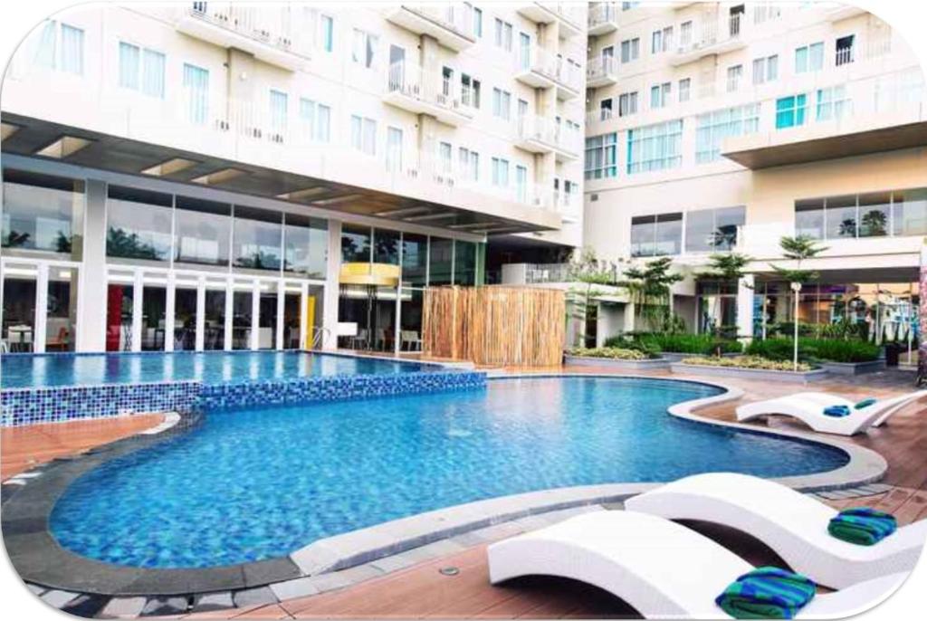 a large swimming pool in front of a building at Channel Stay @ Bogor Icon Apartment in Bogor