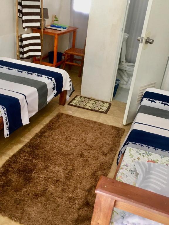 a living room with two beds and a rug at DN Lodge 2 in Daanbantayan