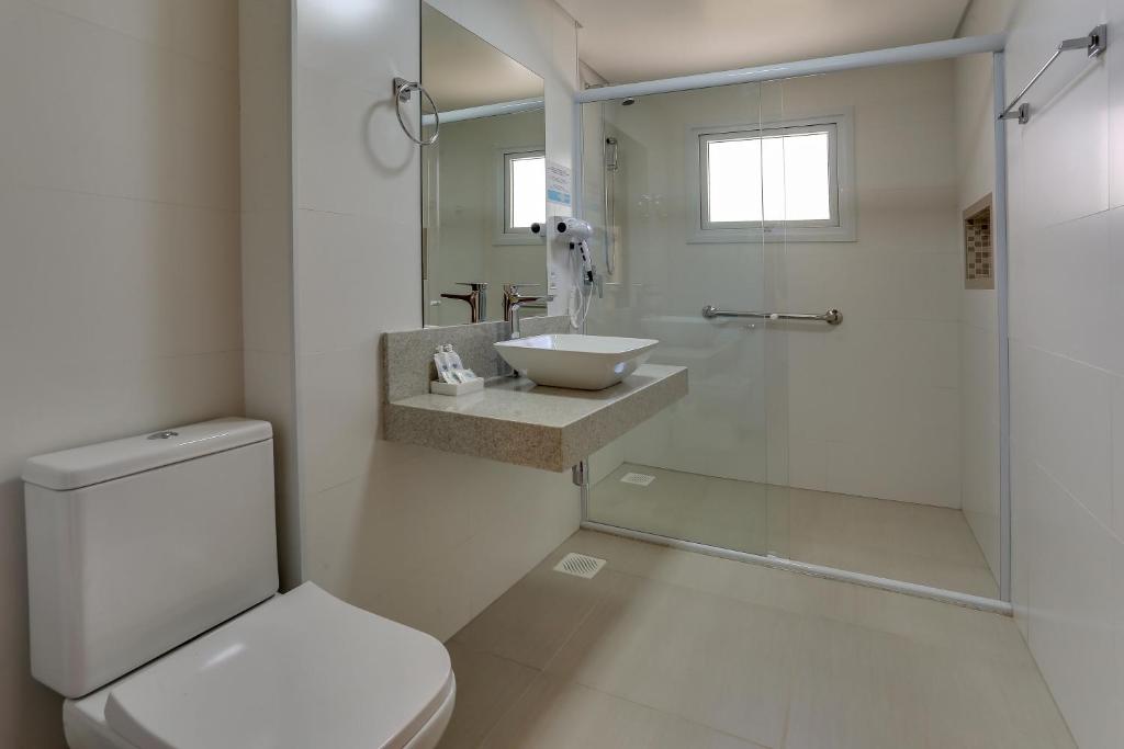 a white bathroom with a sink and a toilet at Pousada Ilha Faceira in Florianópolis