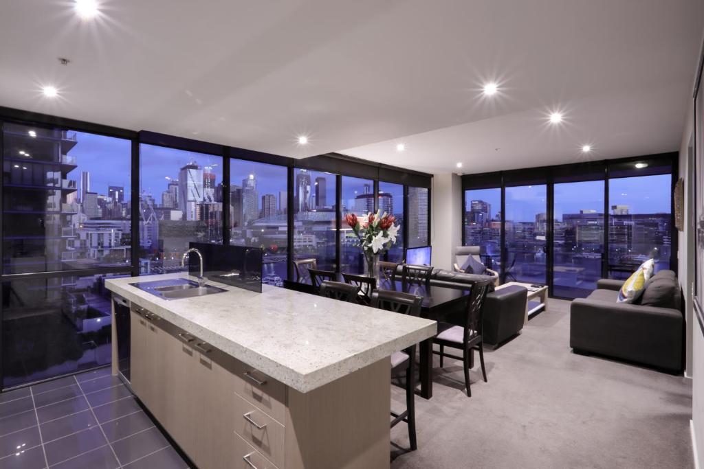 a kitchen and living room with a view of the city at AKOM AT Docklands in Melbourne