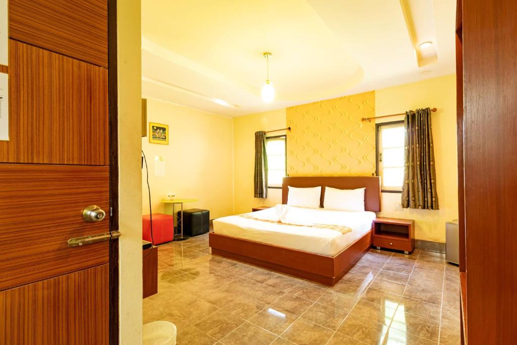 um quarto de hotel com uma cama e uma porta em Ban Suan Chomdao Resort em Songkhla