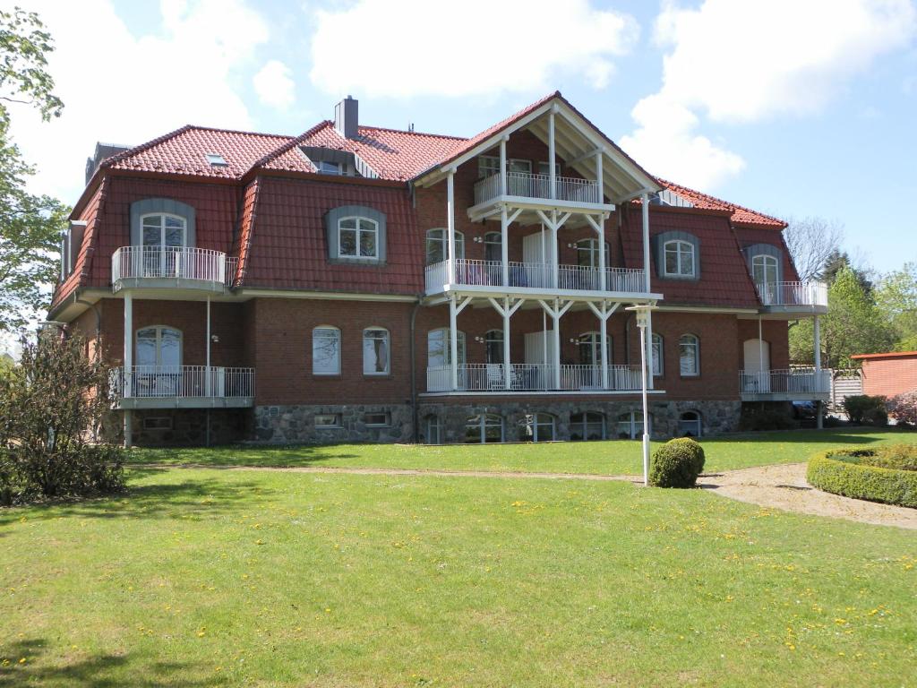 ein großes rotes Backsteinhaus mit großem Hof in der Unterkunft Villa Seegarten in Boltenhagen
