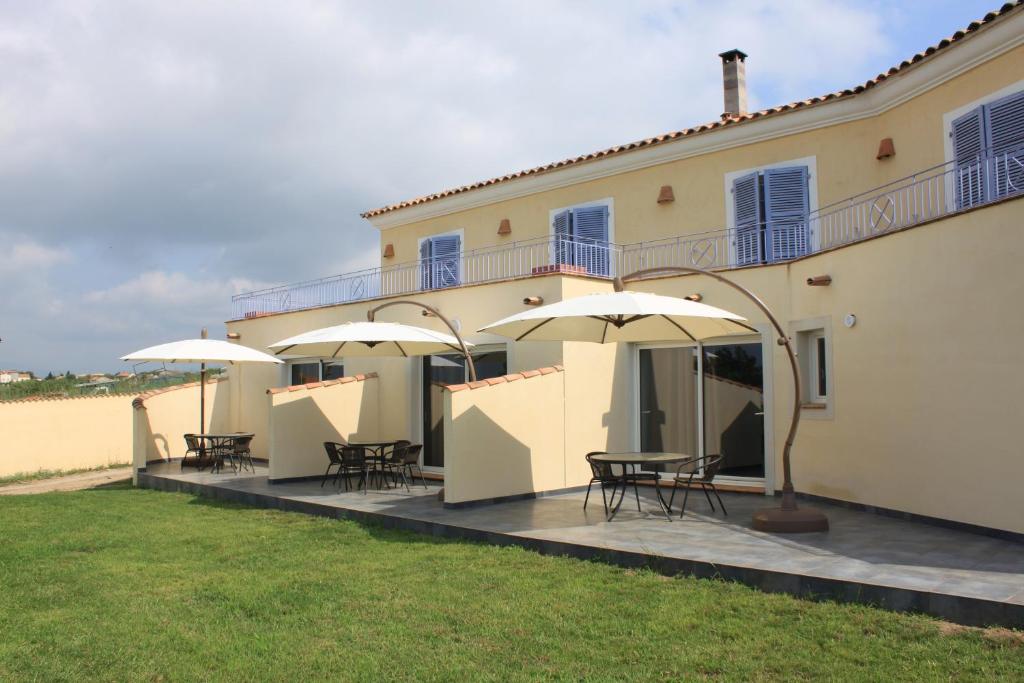 een patio met tafels en parasols voor een gebouw bij E Cabanacce in Aléria