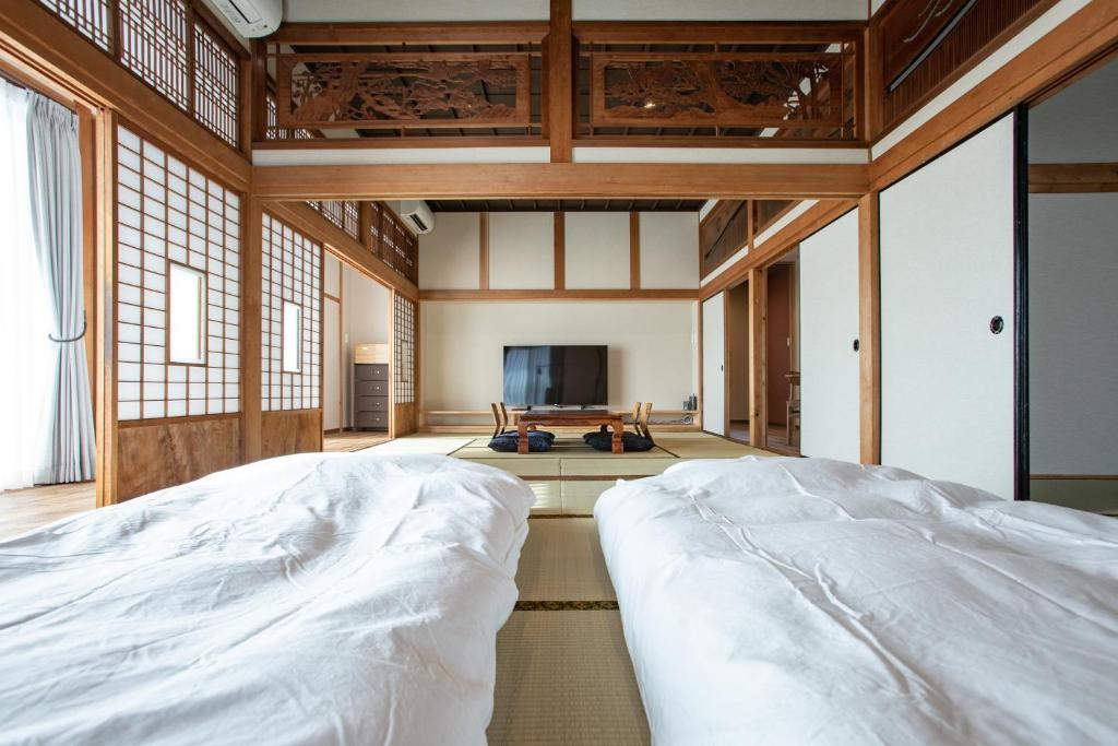 a bedroom with a large bed and a television at 壽宿 Kotohogu Yado in Kajiki