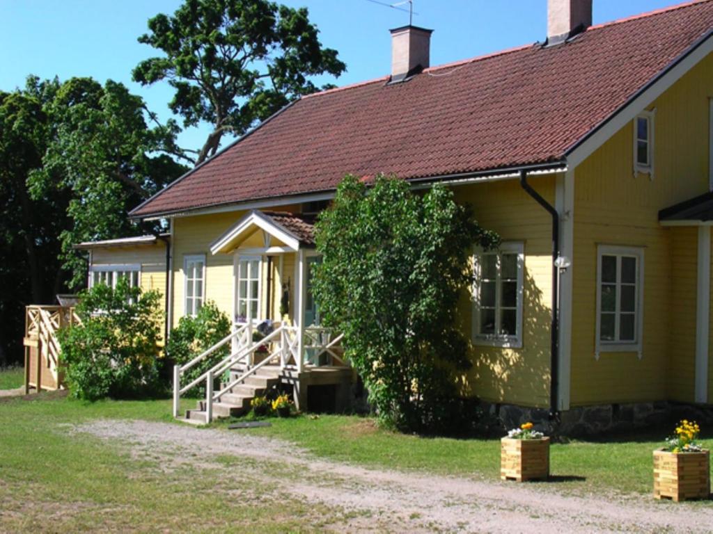 a yellow house with a staircase leading to it at Gula Villan in Utö