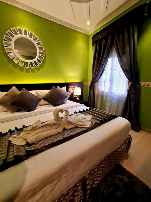 a bedroom with a large bed with a mirror on the wall at West Liberty in Jeddah