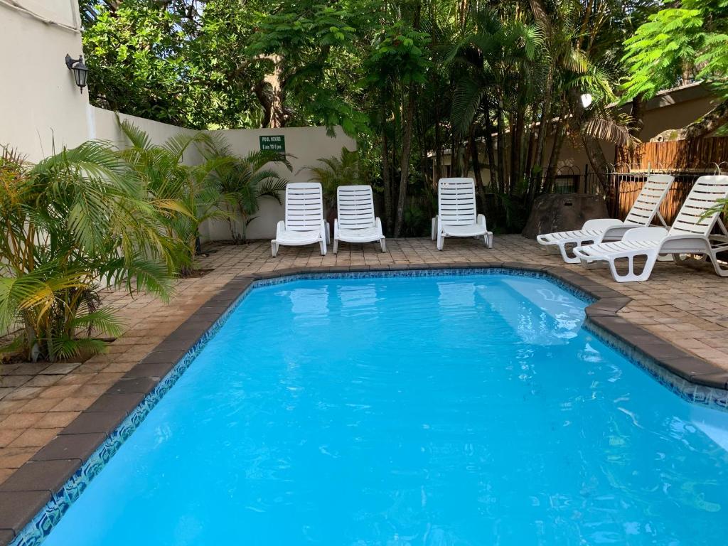 a swimming pool with lounge chairs and a swimming pool at St Lucia Palms in St Lucia