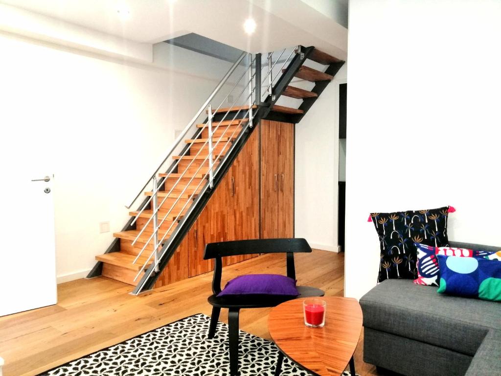 een woonkamer met een stoel en een trap bij REMA Apartments Lustkandlgasse in Wenen
