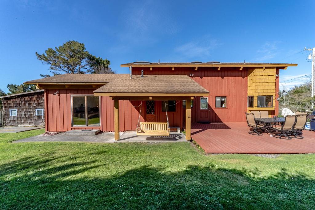 une grange rouge avec une terrasse et une maison dans l'établissement Big Bay Cabin, à Eureka